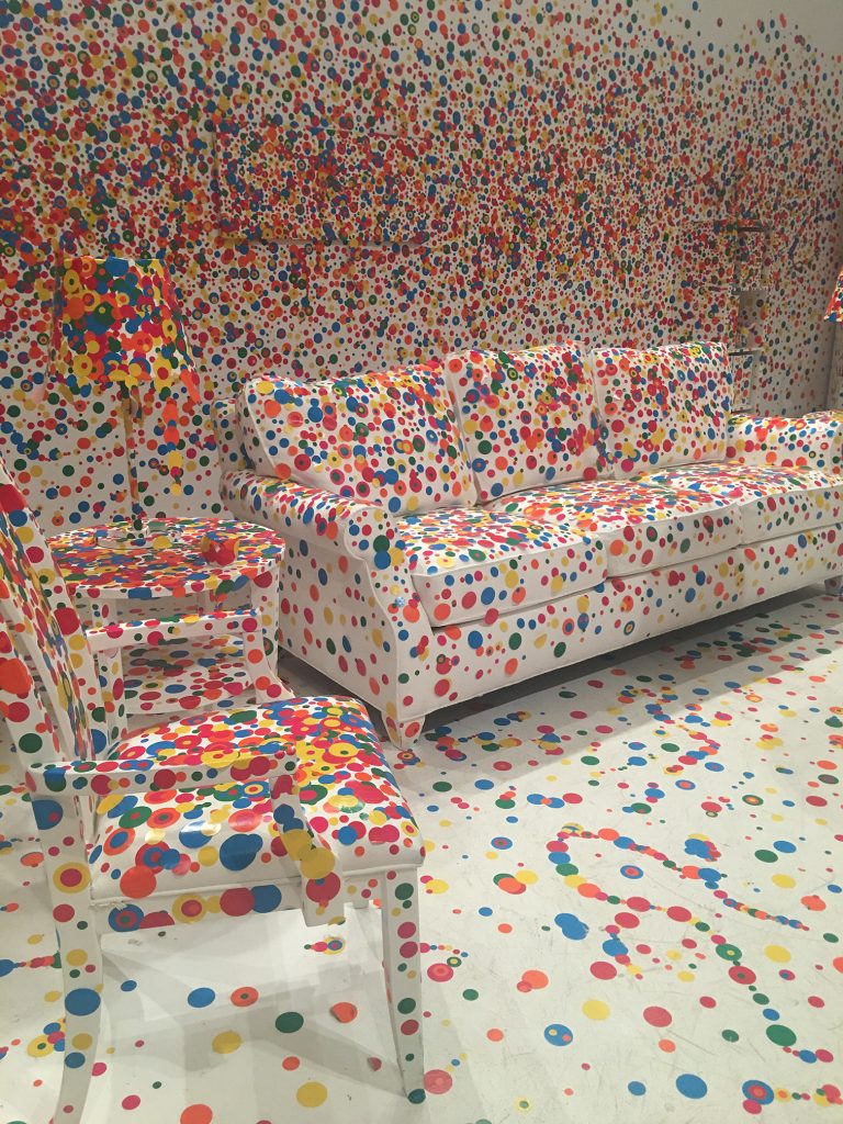 multi colored polka dots cover pure white furniture in a pure white room